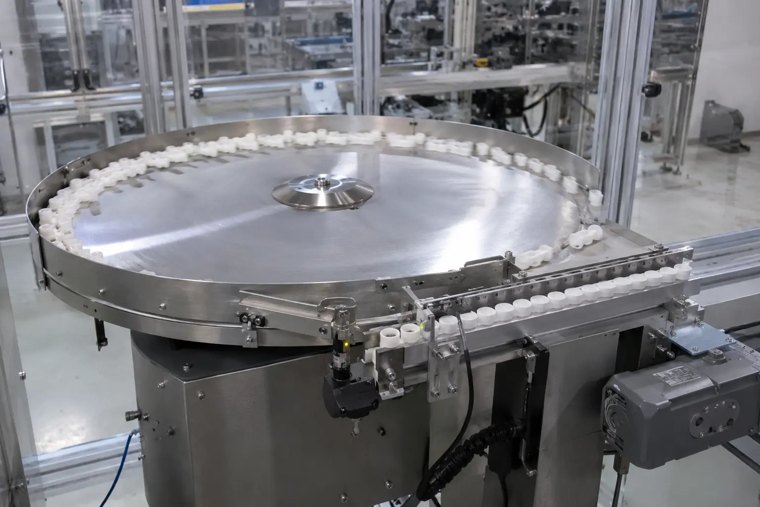 Circular feeder with white components around its rim and along an adjoining track.